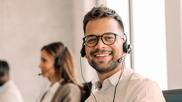 Accessibility | UFK-Guarantees A call center agent looks friendly to the camera.