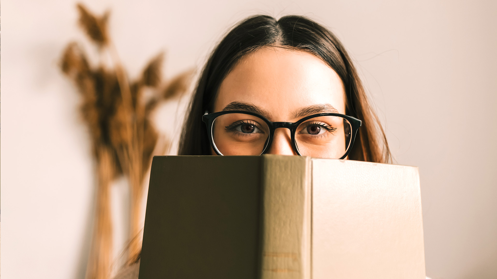 Eine Frau schaut über ein Buch.